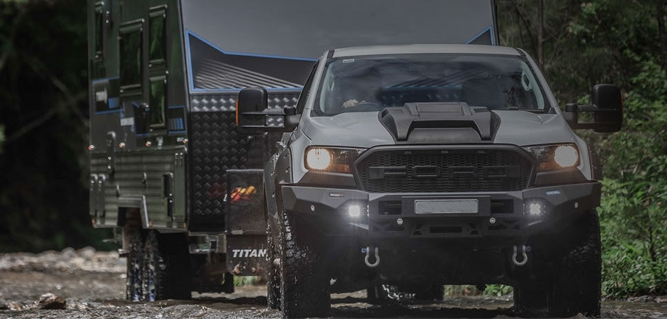 Ford Ranger truck with a camper shell in a forest setting