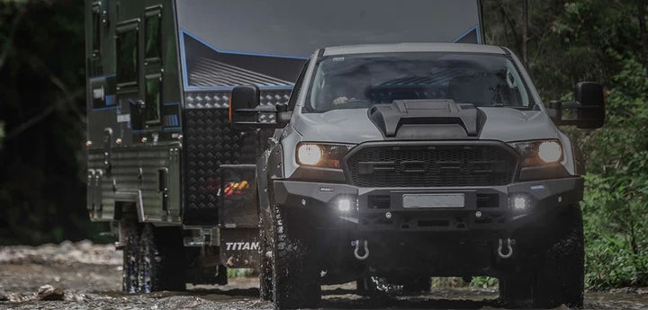 Ford Ranger truck with a camper shell in a forest setting