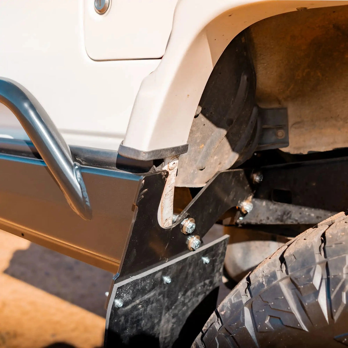Close-up of a vehicle's undercarriage with a metal bumper and tire – TCC 78 Series Troop carrier Rear Bar Tow Bar