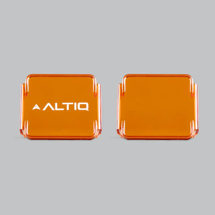 Two amber DX4 lens covers side by side against grey, the left one carrying the ALTIQ name and the right one plain