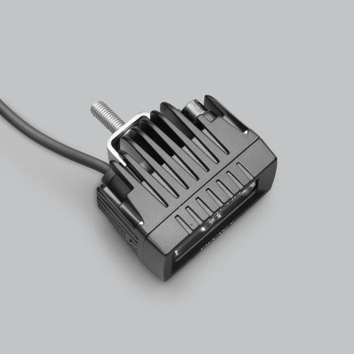 ALTIQ CX2 work light from above and behind, showing the finned cast heatsink, the threaded mounting stud and the cable leaving the rear