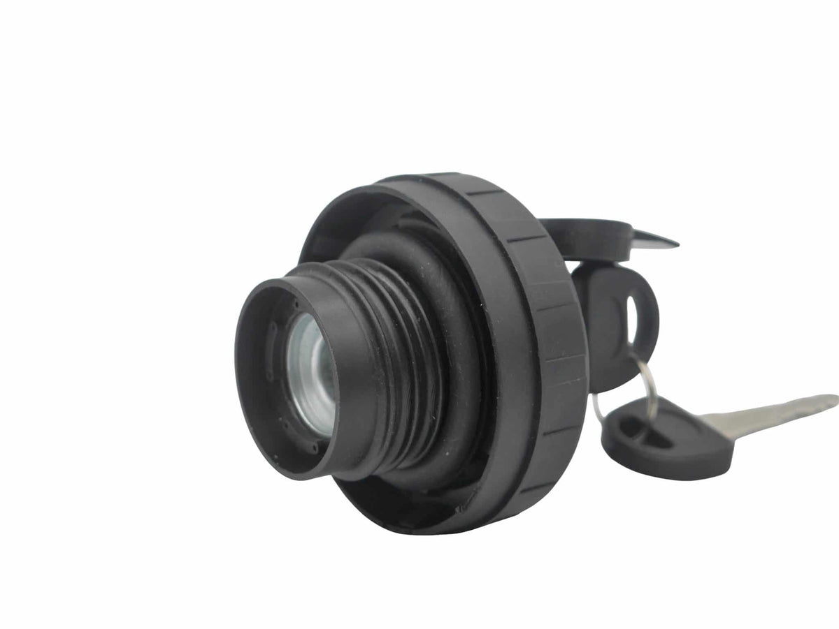 Black plastic locking fuel cap for the wafer tank, the threaded neck and sealing gasket facing the camera, with the key in the barrel and a second key on the ring