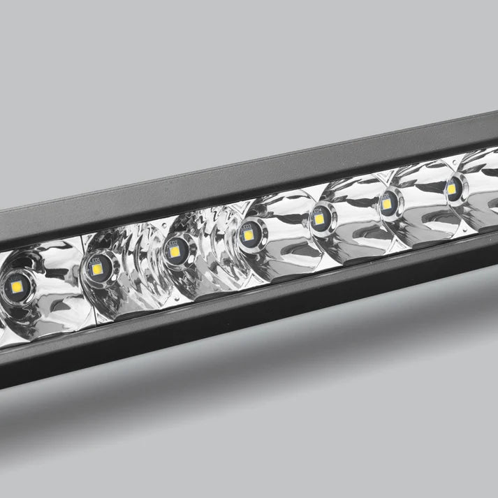 Close-up across the spot section of the bar, a row of LEDs each sitting in a deep polished reflector behind the lens