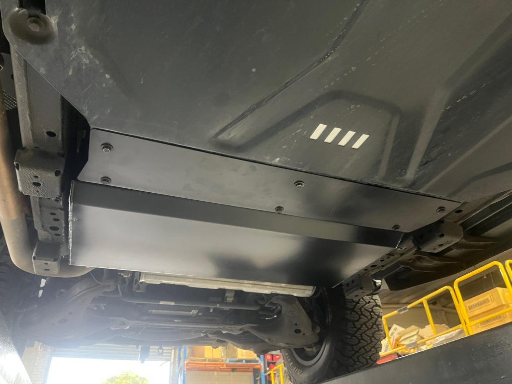 Close-up of a vehicle's undercarriage with a metal guard