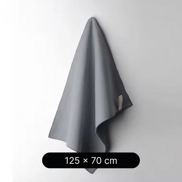 Gray towel hanging on a white wall with dimensions 125 x 70 cm displayed below.