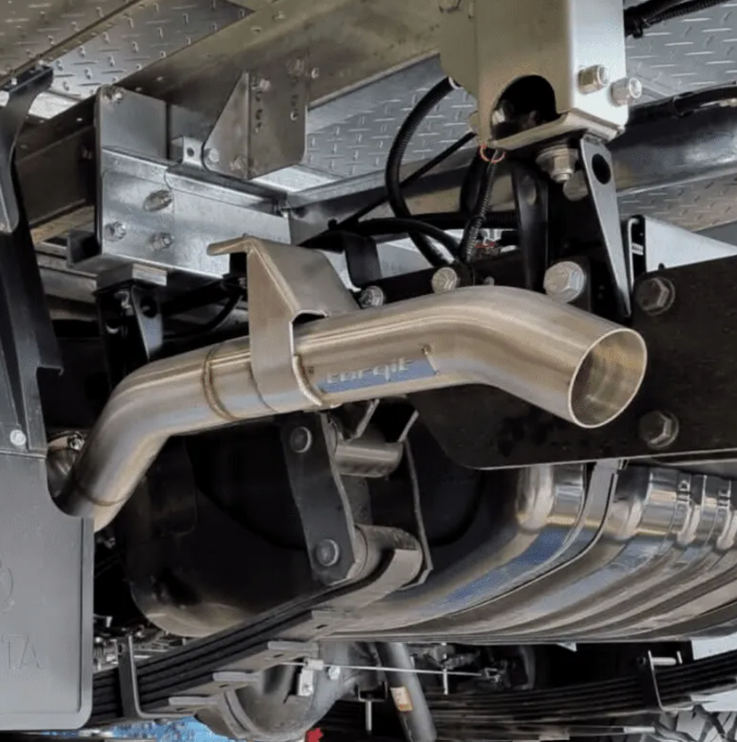 Close-up of a car exhaust system with 'torqit' branding.