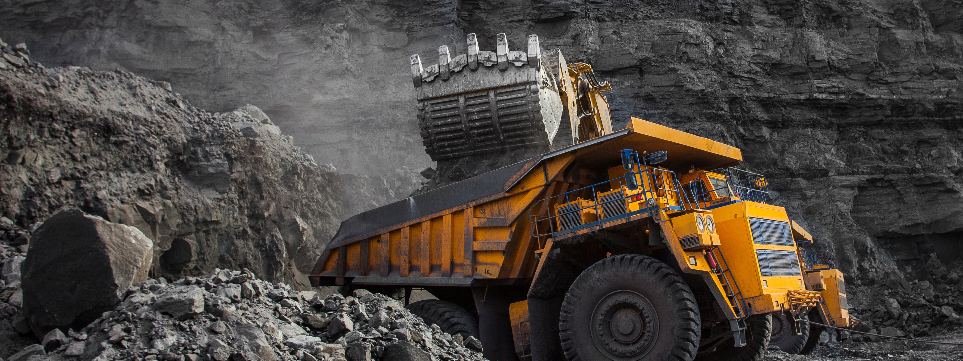 Yellow dump truck in a rocky mining environment