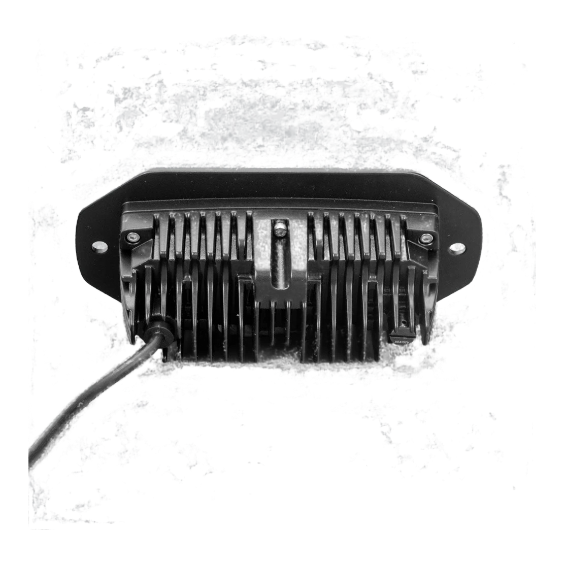 The CX4 flush mount seen square on from behind, the finned heatsink centred in the flange with a fixing hole at each end and the lead running out to one side