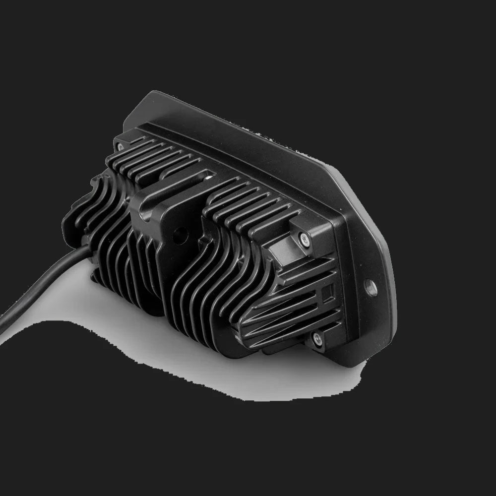 Rear of the CX4 flush mount light, showing the deep finned heatsink behind the mounting flange, the retaining screws and the cable leaving the back