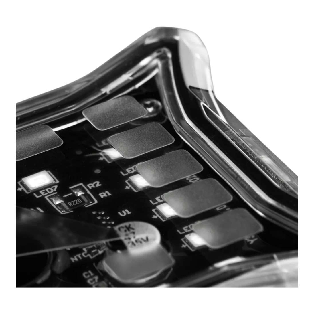 Close-up inside an ALTIQ Spectrum Pro rock light, the clear lens over the circuit board with its surface-mount LEDs, the numbered LED positions and the electrolytic capacitor rated 47 microfarads at 35 volts