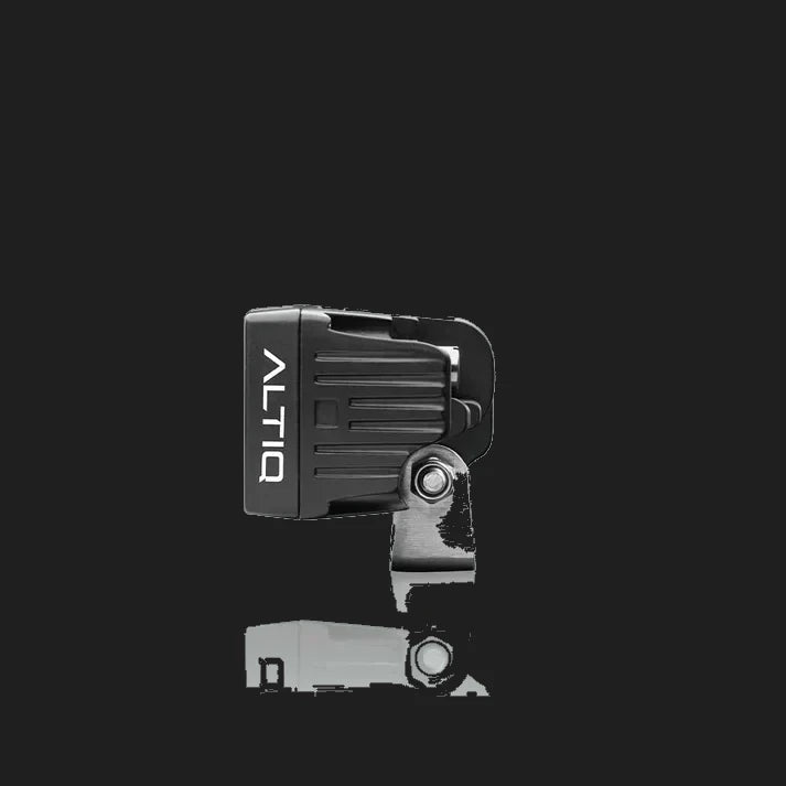 ALTIQ CX2 work light seen from the side, the ribbed black housing with the ALTIQ name down the face and the stainless mounting bracket and bolt below