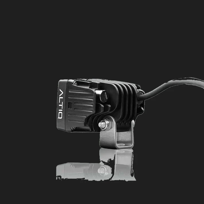 ALTIQ CX2 work light from the opposite side, the ALTIQ name on the housing with the mounting bracket bolted through and the lead running away behind