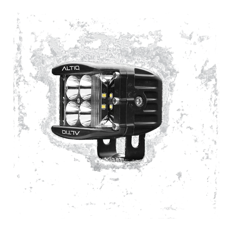 DX4 hybrid work light turned further round, the four spot reflectors and the amber-tinted side flood LEDs both visible with the ALTIQ name on the bezel