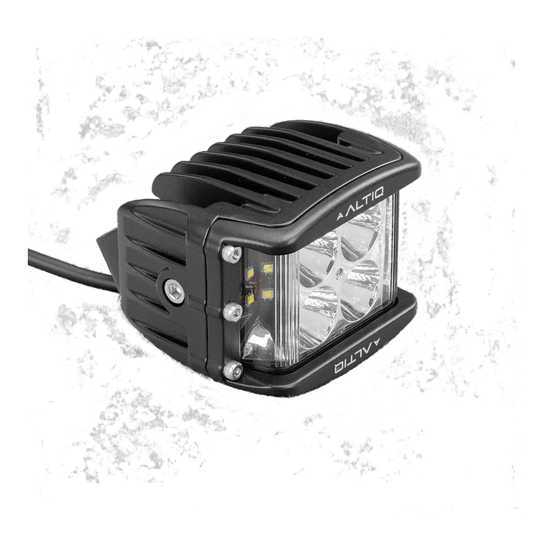 DX4 hybrid work light at a three-quarter angle, showing the round spot optics and the side flood strip together behind the clear lens