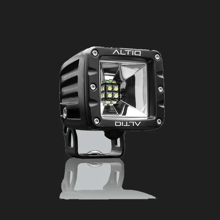 Black DX4 Scene work light at a three-quarter angle, the ALTIQ name on the bezel above a square reflector with nine LEDs, mounted on its black bracket