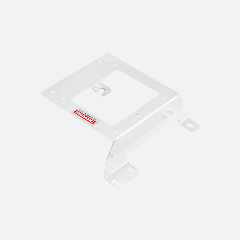 White Redarc mounting bracket at a shallow angle, a plate with a central cut-out, a hooked retaining tab and two slotted mounting feet
