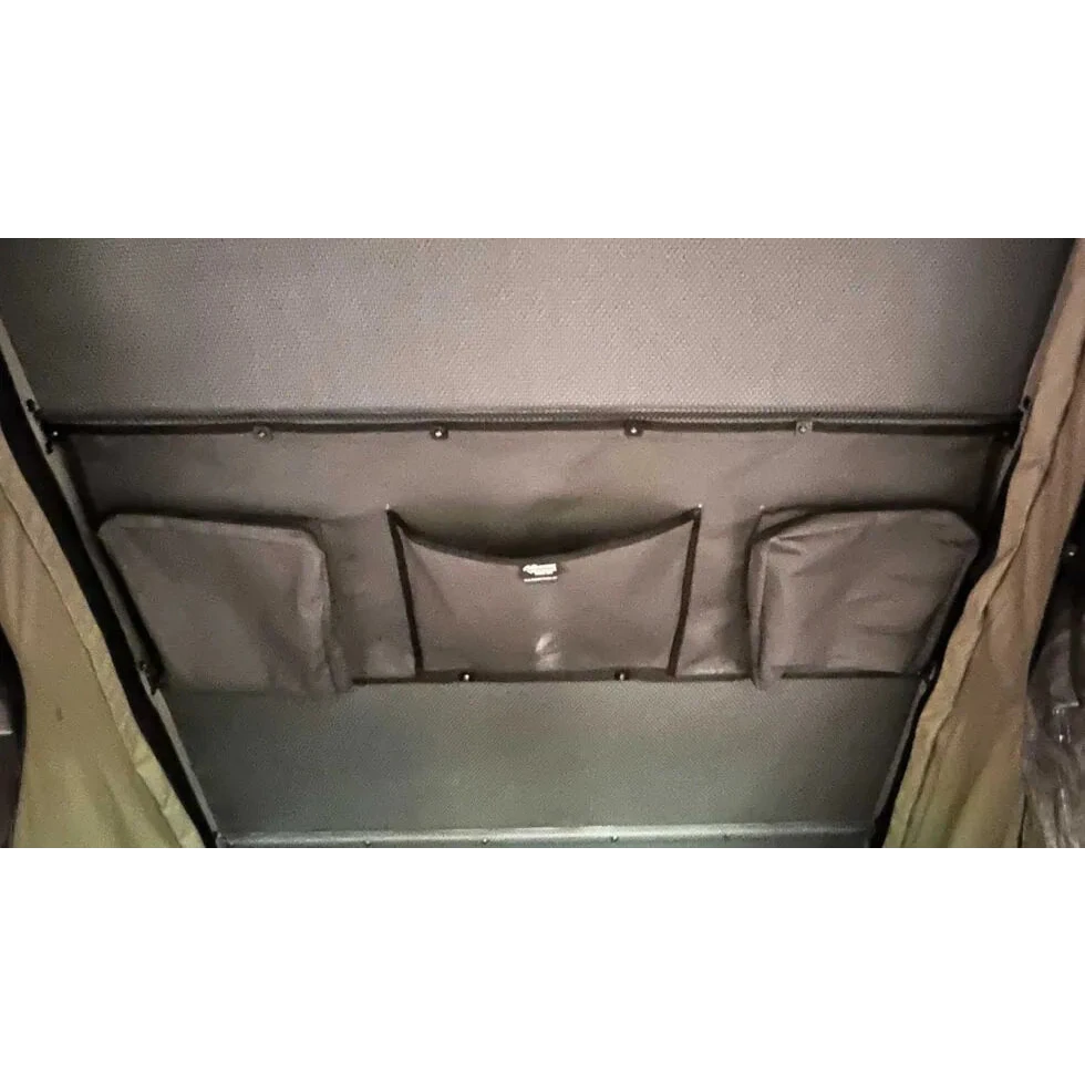Gray storage compartment with multiple pockets on a vehicle interior – Bush Company LX27 Gen2 Lightweight Clamshell Rooftop Tent