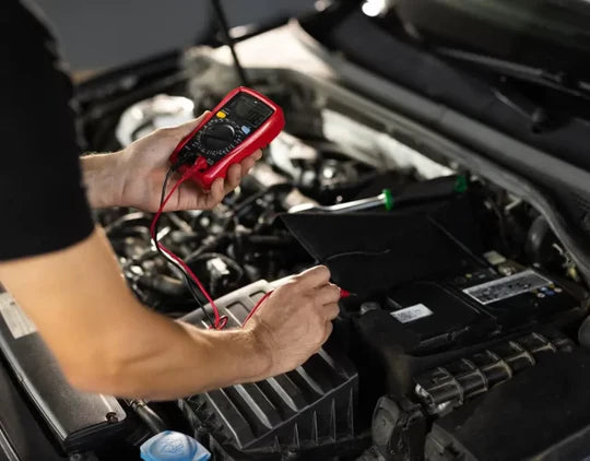 Person using a multimeter to check a car battery
