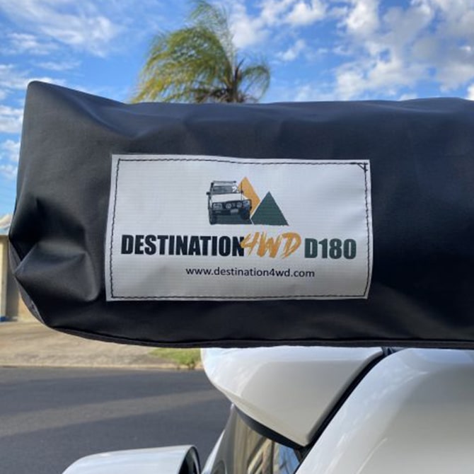 Black cover with 'Destination 4WD D180' logo on a vehicle, with palm trees and blue sky in the background.