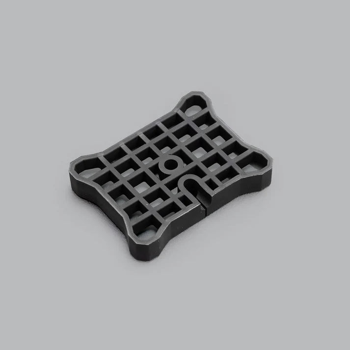 Underside of the flat mount, showing the moulded lattice of ribs across the base and the cable slot cut through one edge