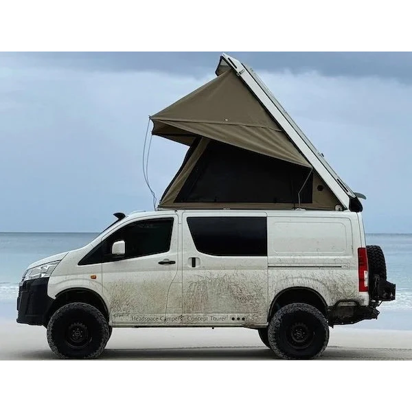 Van with an extended roof tent on a beach