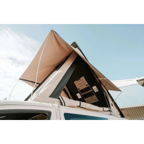 Car with an extended rooftop tent against a clear sky – Headspace Roof Conversion HiAce