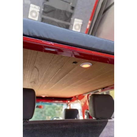 Headspace Roof Conversion LC76 – wooden ceiling panel in a vehicle with headrests and a window in the background
