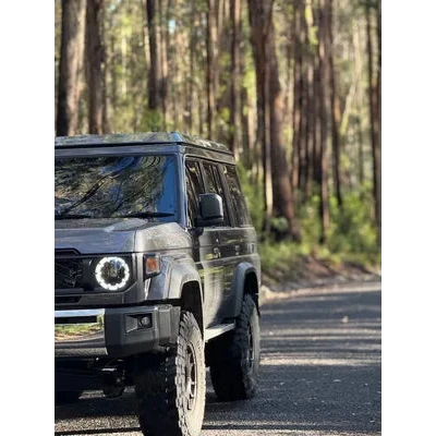 SUV driving on a road surrounded by trees – Headspace Roof Conversion LC76