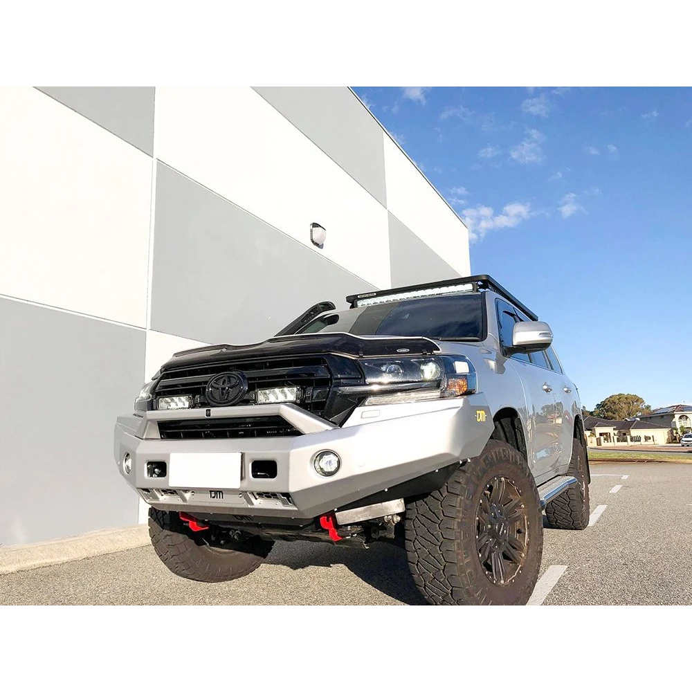 Toyota SUV with off-road modifications parked on a road with a building and blue sky in the background with Lazer Lamps Grille Kit – Toyota Land Cruiser 200 Series (2015–2021)