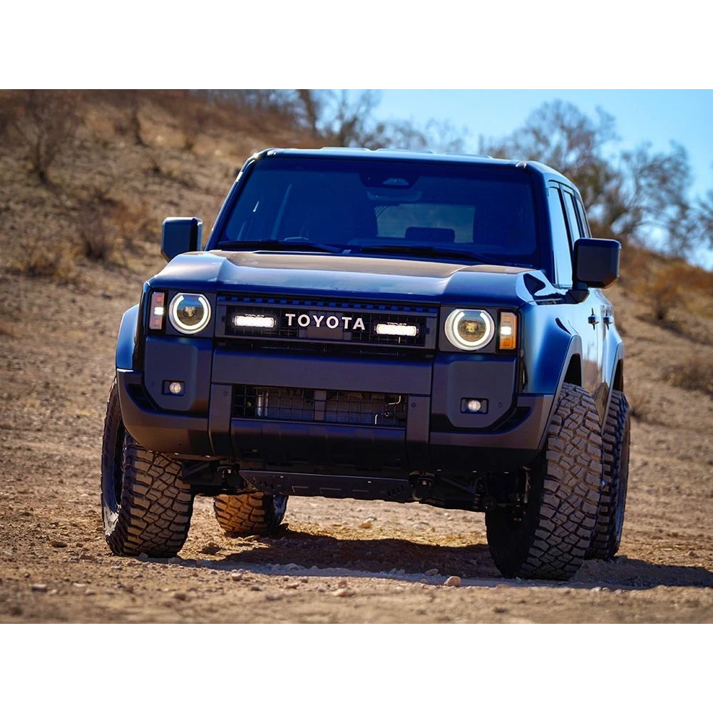 Blue Toyota Prado 250 on a dirt road with a clear sky and Lazer Lamps ST4 Evolution Grille Kit – Land Cruiser 250 (2024+)