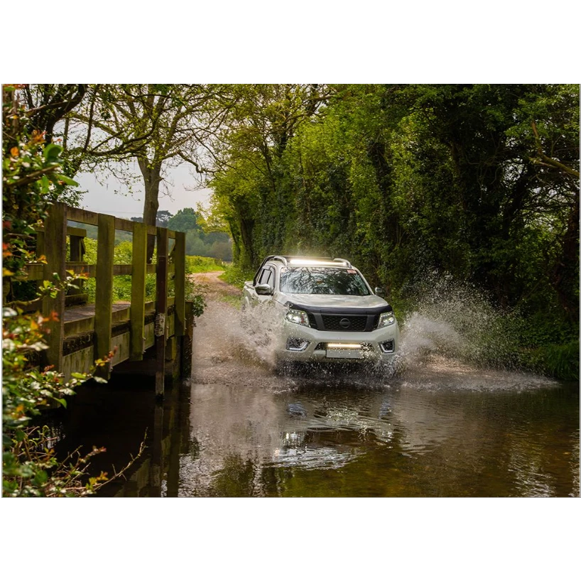 White SUV driving through a shallow stream on a forest road