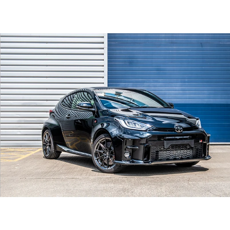 Black Toyota car parked in front of a blue and gray striped wall with Lazer Lamps Bumper Beam Mount Kit for Toyota Yaris GR