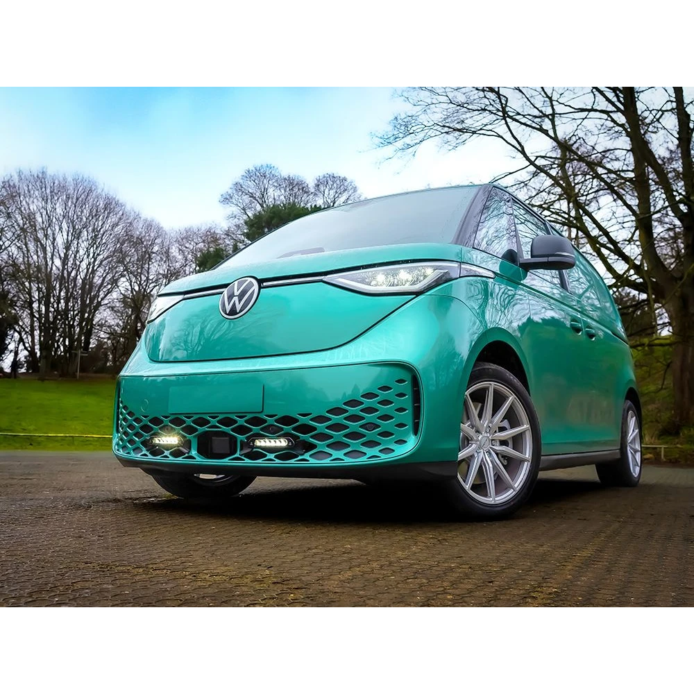 Turquoise Volkswagen car parked on a road with trees in the background with Lazer Lamps Grille Kit for VW ID Buzz (2025+)