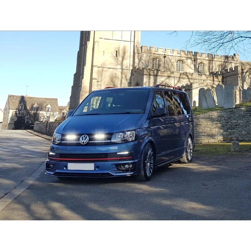 Blue Volkswagen van parked in front of a castle-like building
