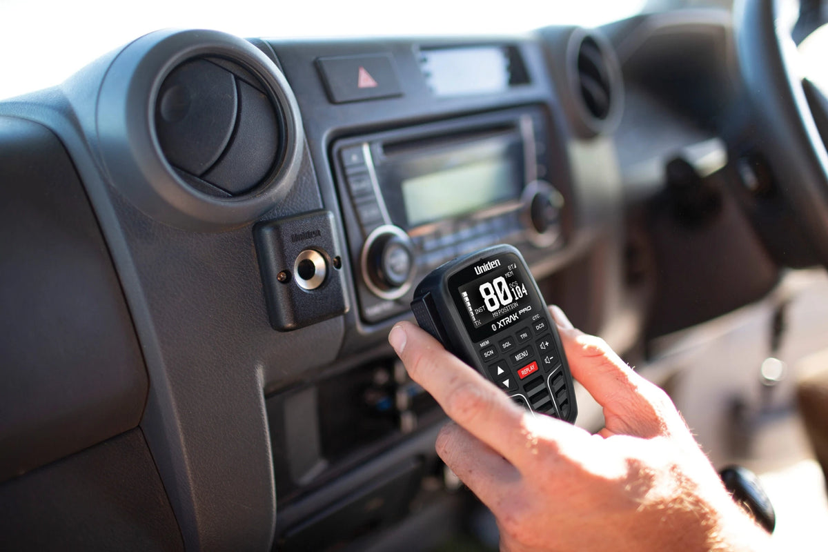 Magnetic Microphone Mount For Uniden UHF-CB Mobiles – mounted in a vehicle dash with the microphone in hand