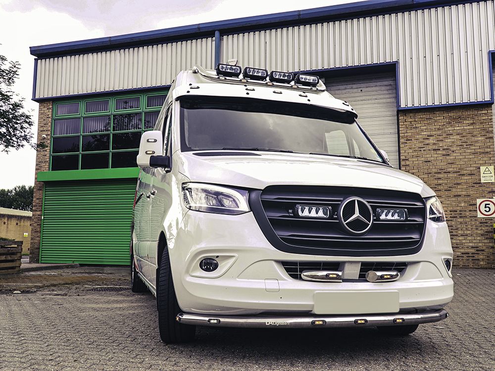 White Mercedes-Benz van in front of a building