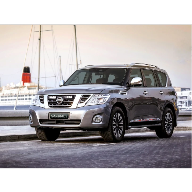 Silver Nissan Patrol SUV parked on a dock with a ship in the background with Lazer Lamps Nissan Patrol Y62 2018-2019 Grille Mount