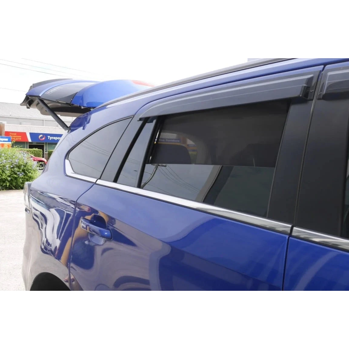 SnapShades Isuzu MU-X Rear Window Shades (RJ 2020+) – blue MU-X with a roof rack in a car park, shades fitted