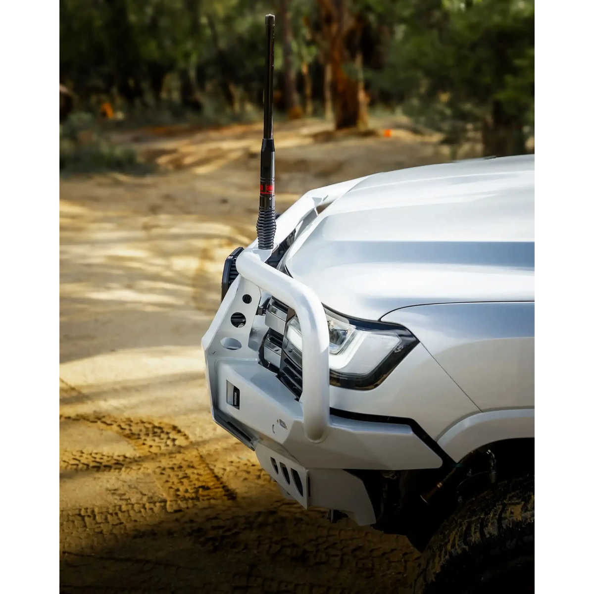 White off-road vehicle with a front bumper and antenna on a dirt road – TCC Toyota LandCruiser 300 Series Bull Bar