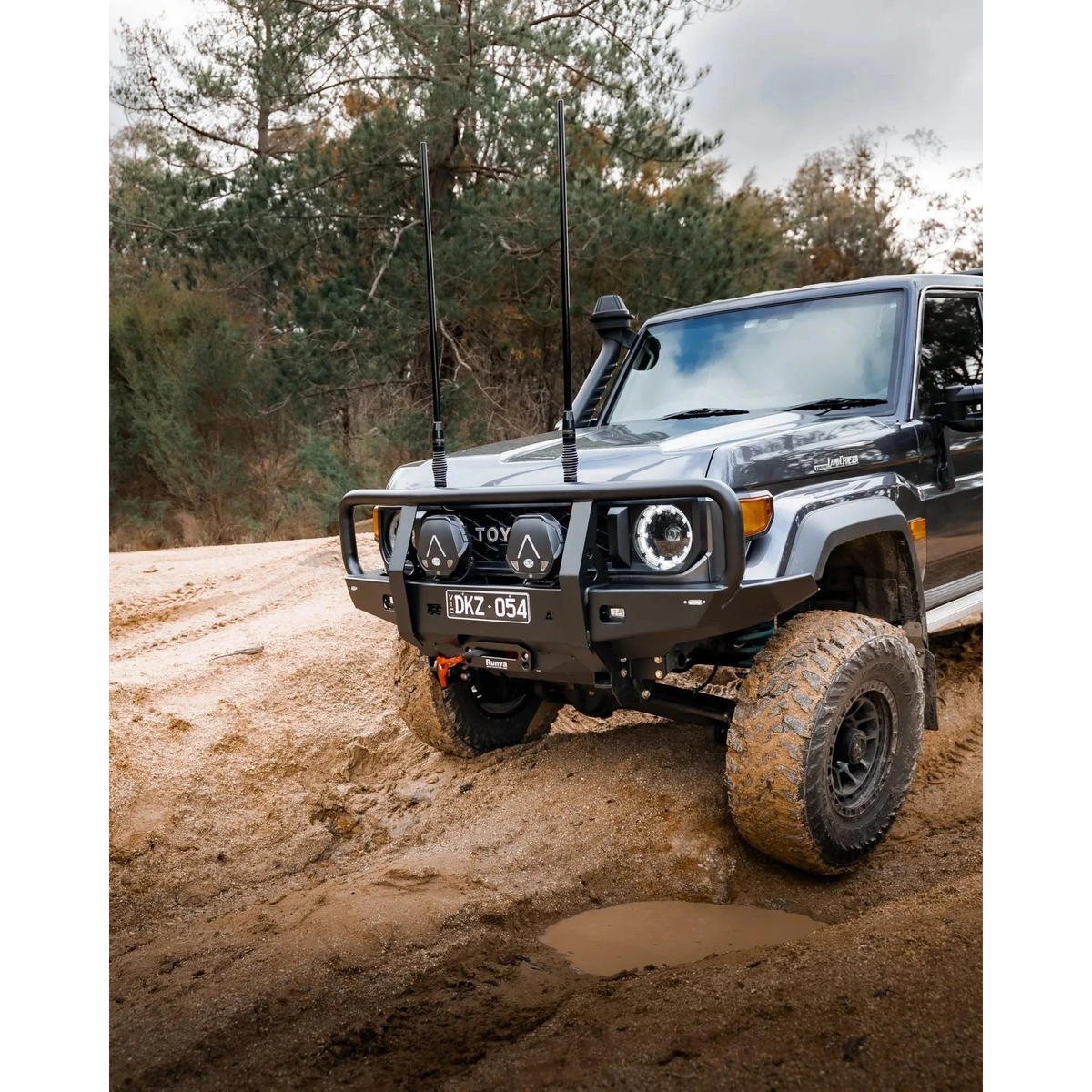 Toyota SUV driving on a dirt road with trees in the background – TCC 70 Series Bull Bar - Facelift (2024 - Present)