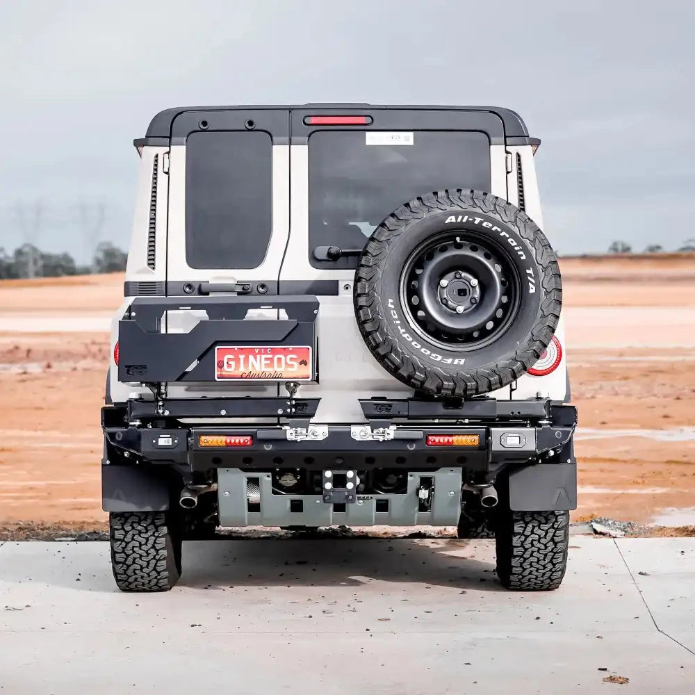 TCC INEOS Grenadier Rear Bar – back view of a white Grenadier with the spare tyre mounted, on a concrete surface