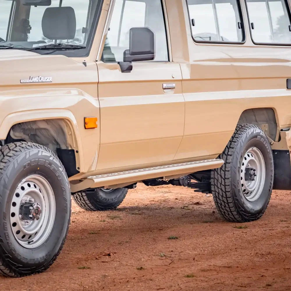 Beige off-road vehicle on a dirt road – TCC Toyota LC78 Troopcarrier Side Steps