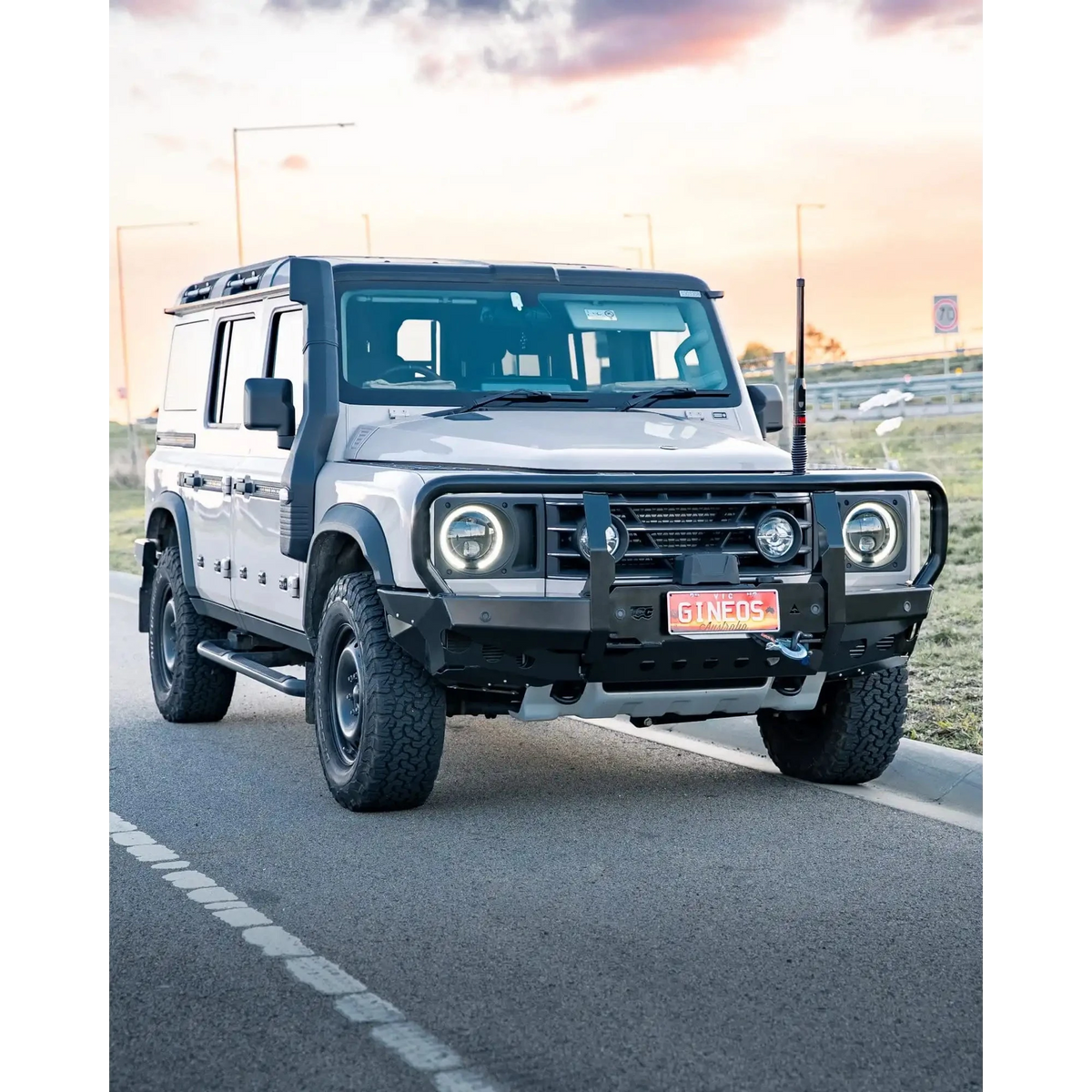 White off-road vehicle on a road with a sunset in the background – TCC Ineos Grenadier Bull Bar