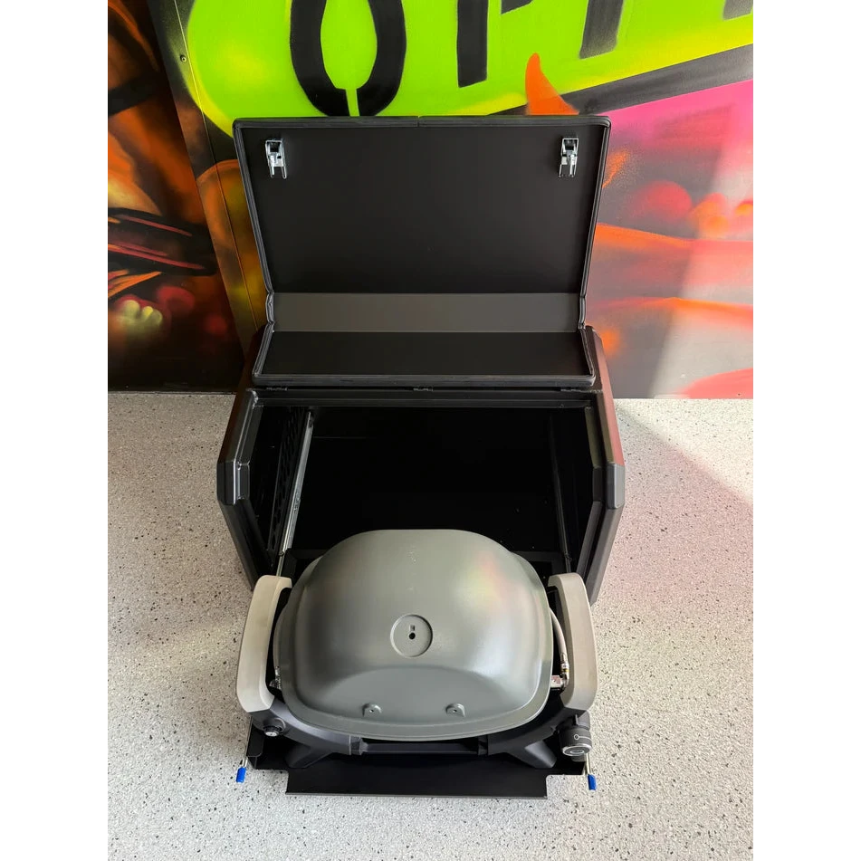 Thorburns BBQ 2.0 Accessory – portable grill with lid open on a concrete floor, with a colourful background.