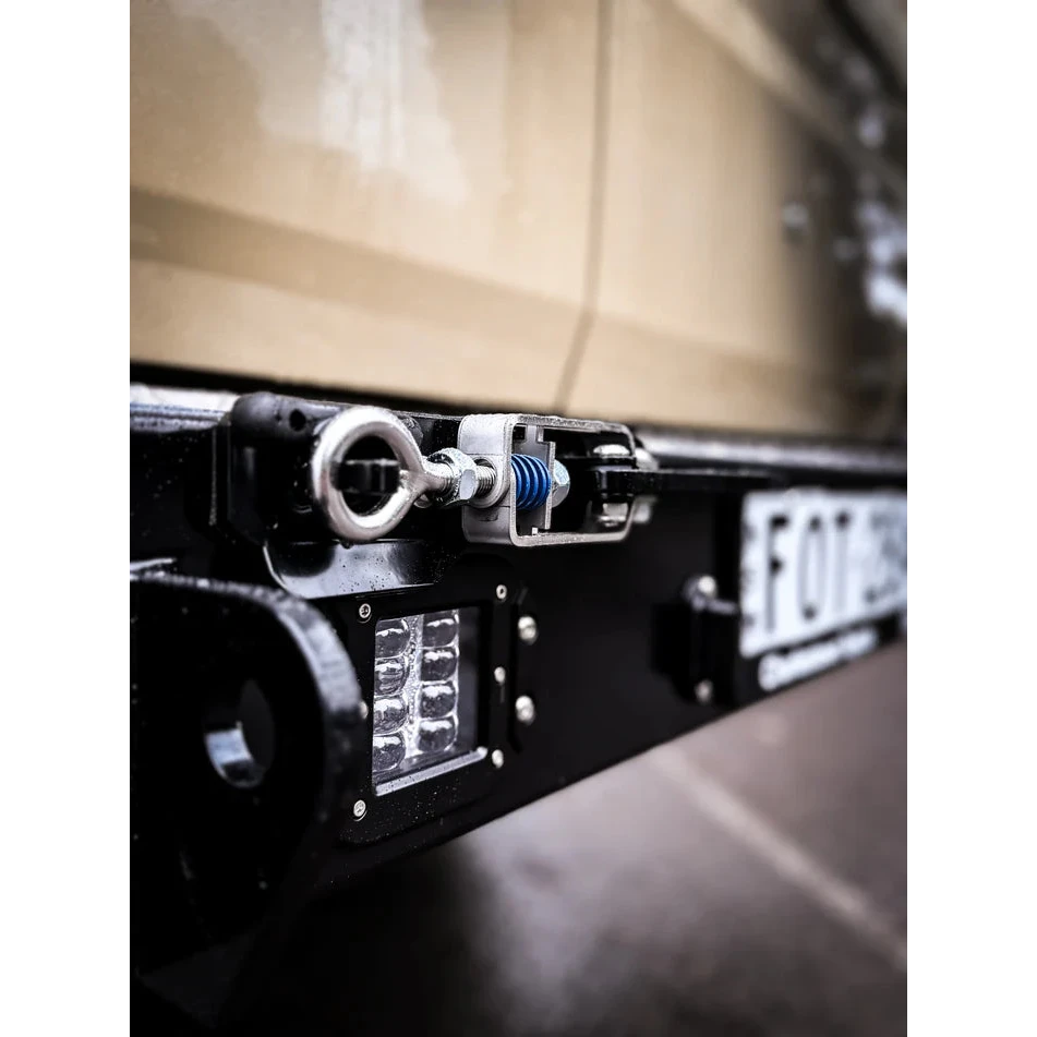 Thorburns LC75/78 Rear Bar – close-up of a vehicle's licence plate and light system with a blurred background.