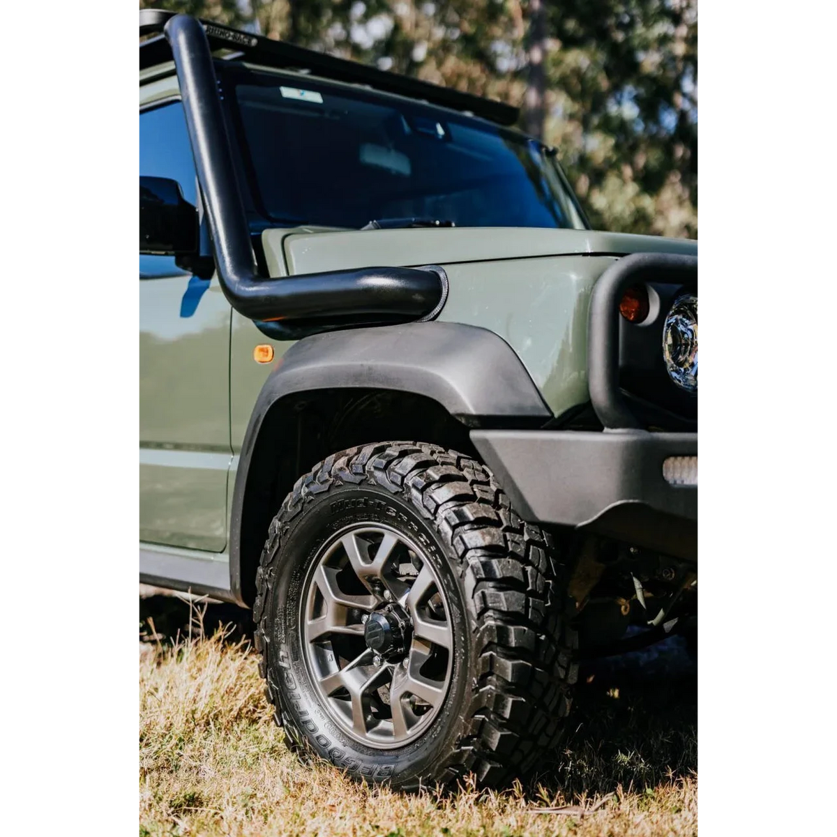 Green Suzuki Jimny with snorkel and bumper on grassy terrain – Torqit 3.5" Stainless Steel Snorkel (Matte Black) for Suzuki Jimny (JB74 / JC74 XL)