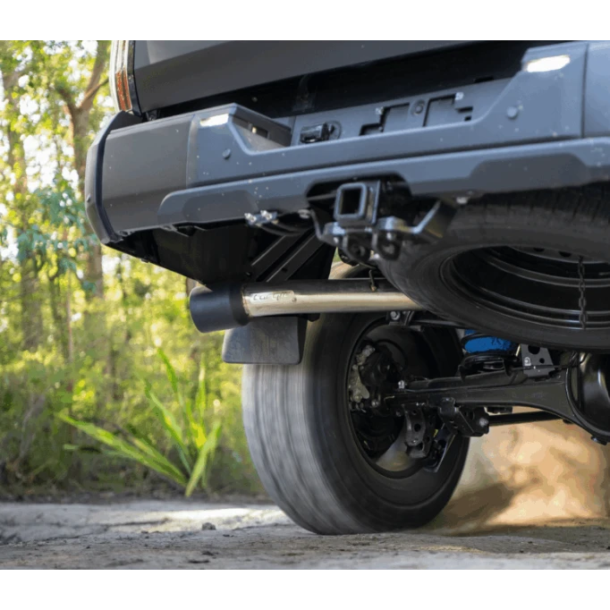 Close-up of a vehicle's undercarriage with a forest background – Torqit 3″ CAT Back Performance EXHAUST Toyota Tundra 3.5L V6 Petrol