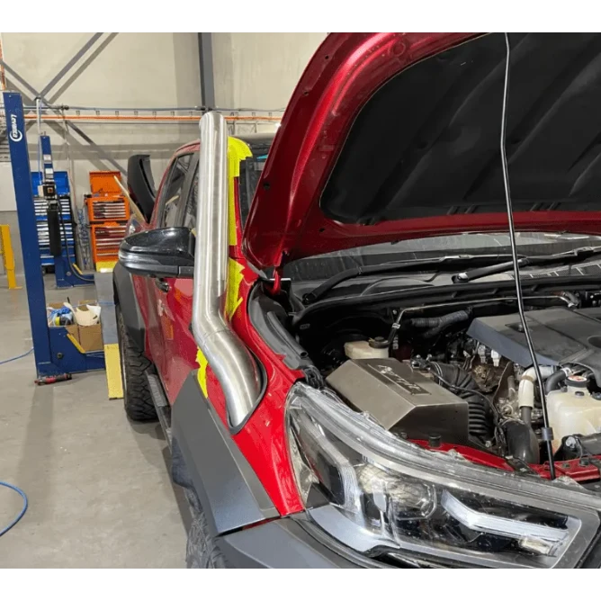 Red Toyota Hilux in a workshop – Torqit Stainless Steel Airbox (Matte Black) for Toyota Hilux 2.8L