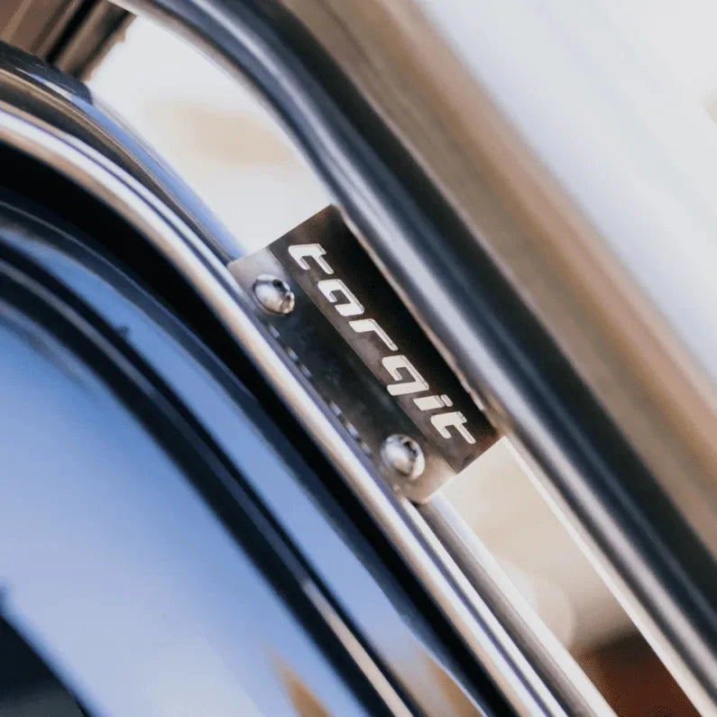 Close-up of the stainless Torqit badge plate bolted to the snorkel body where it meets the A-pillar, the brand name cut into the brushed metal