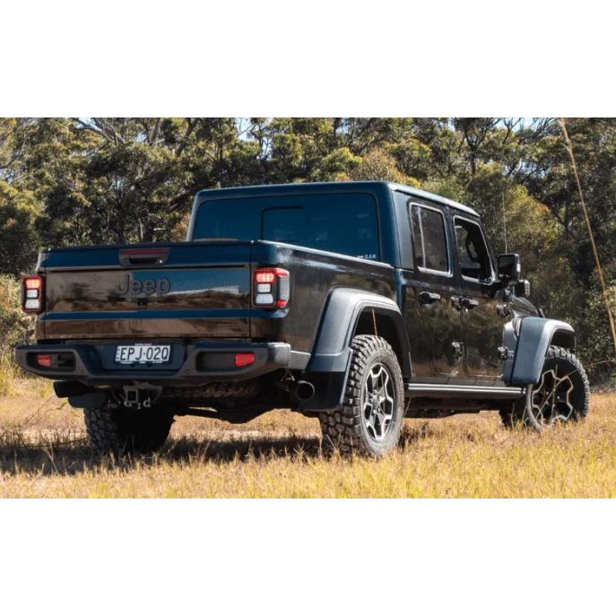 Black Jeep truck in a natural setting with trees and grass – Torqit Twin Exit 3″ Cat Back Performance Exhaust for Jeep Gladiator 2020+